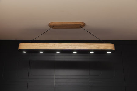 wooden lamp that rises from the ceiling, close up, copy space