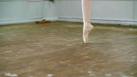 close up, in dancing hall, ballerina perform step pointe , She is standing on toes in pointe shoes...
