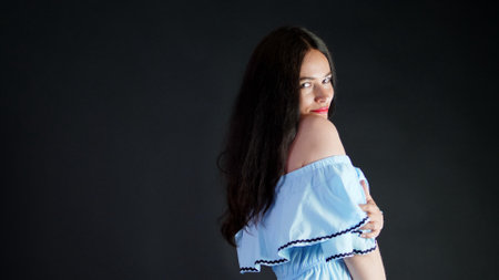 portrait of a sexy brunette woman with red lips who eroticly and playfully moves and looking sexually at camera, posing in studio. dark gray background. High quality photoの写真素材