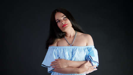 portrait of a sexy brunette woman with red lips who eroticly and playfully moves and looking sexually at camera, posing in studio. dark gray background. High quality photoの写真素材