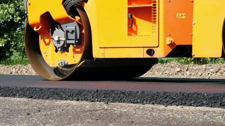 close-up, Road construction works with roller compactor machine and asphalt finisher. Road roller...