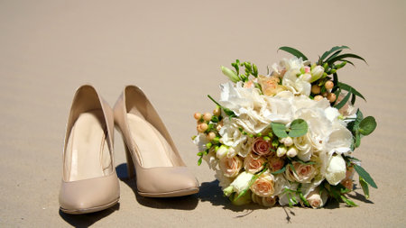 summer, desert, wedding female beige heels stand on the sand, next to the wedding bouquet. Day,. High quality photoの写真素材