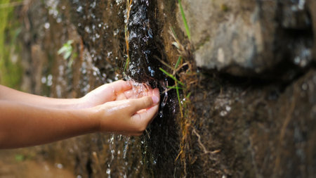 close-up, childrens hands. a child washes his hands in the clear, transparent water of a mountain...