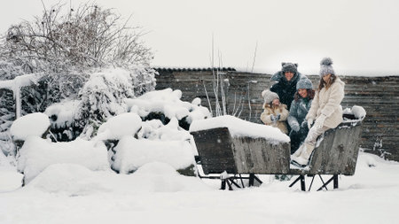 winter family fun. throwing snow. Happy, laughing, playful family of 4 is enjoying of snow and snowfall, having fun, spending time together on snowy winter day. slow motion. High quality photoの写真素材