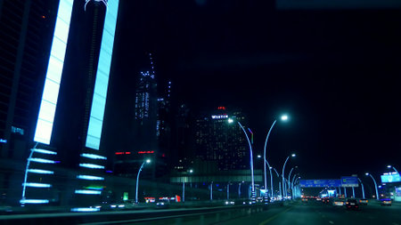 DUBAI, UNITED ARAB EMIRATES, UAE - NOVEMBER 20, 2017: night city of Dubai, roads are lit by flashlights, many cars, whole city is illuminated, view from moving taxi. High quality photoのeditorial素材