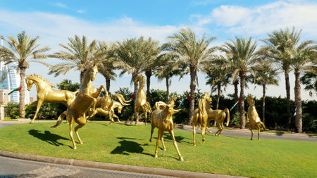 DUBAI, UNITED ARAB EMIRATES, UAE - NOVEMBER 20, 2017: luxury 5 stars Hotel JUMEIRAH Al Qasr Madinat, sculptures of gold horses at the entrance to the hotel complex. High quality photoのeditorial素材