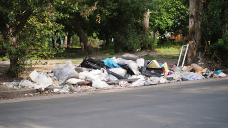on ground, on side of road, lots of garbage is lying. scattered trash, rubbish, old things, car...