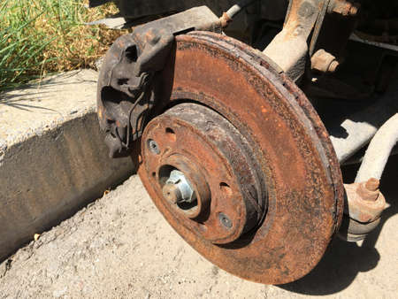 Brakes on a car with removed wheel, rusty brake discの素材