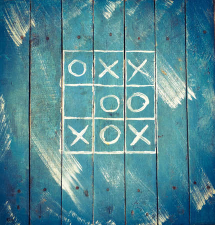 Tic tac toe on a blue wooden old boardの素材