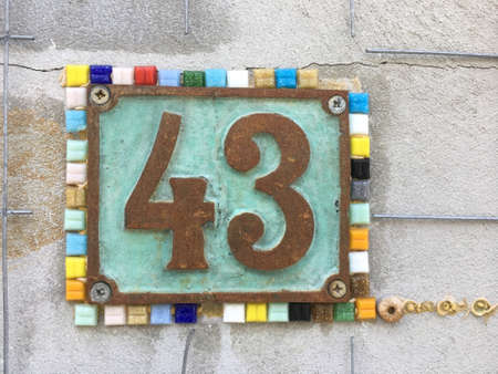 Vintage grunge square metal rusty plate of number of street address with number closeupの素材
