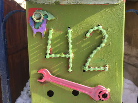 Vintage grunge square metal rusty plate of number of street address with number closeup