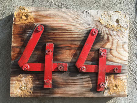 Vintage grunge square metal rusty plate of number of street address with number closeupの素材