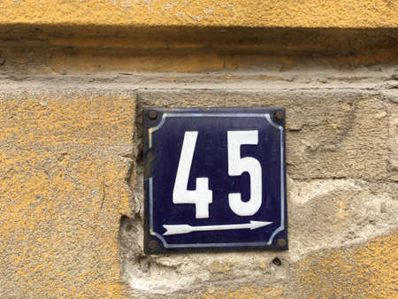 Vintage grunge square metal rusty plate of number of street address with number closeup