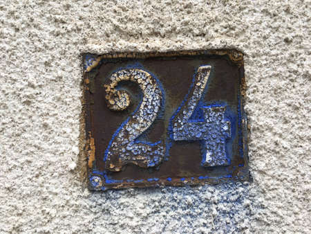 Vintage grunge square metal rusty plate of number of street address with number closeupの素材