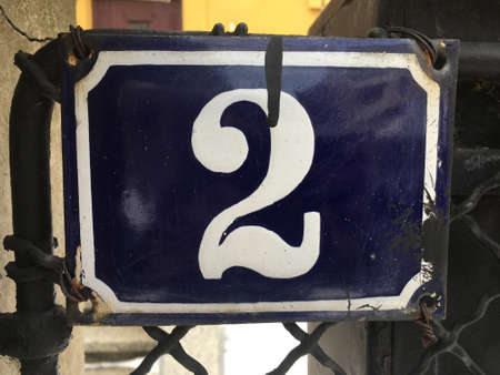 Vintage grunge square metal rusty plate of number of street address with number closeupの素材