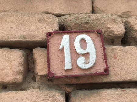 Vintage grunge square metal rusty plate of number of street address with number closeupの素材
