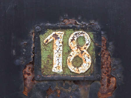 Vintage grunge square metal rusty plate of number of street address with number closeupの素材