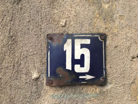 Vintage grunge square metal rusty plate of number of street address with number closeupの素材