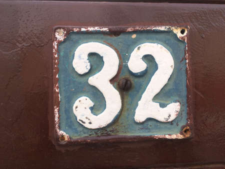 Vintage grunge square metal rusty plate of number of street address with number closeupの素材