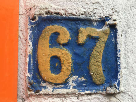 Vintage grunge square metal rusty plate of number of street address with number closeupの素材