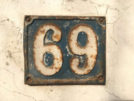 Vintage grunge square metal rusty plate of number of street address with number closeupの素材