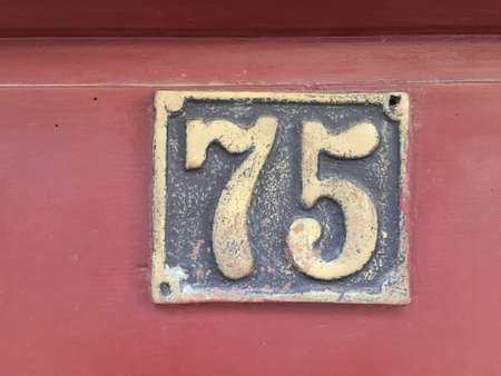 Vintage grunge square metal rusty plate of number of street address with number closeupの素材