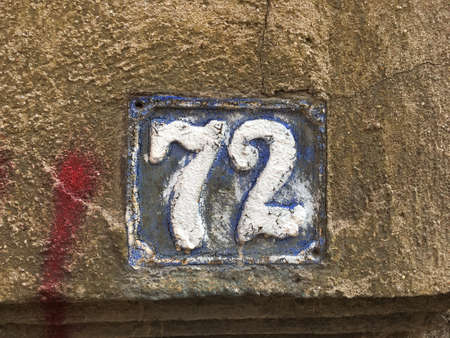 Vintage grunge square metal rusty plate of number of street address with number closeup