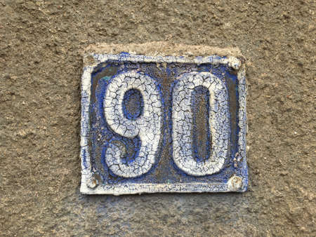 Vintage grunge square metal rusty plate of number of street address with number closeupの素材