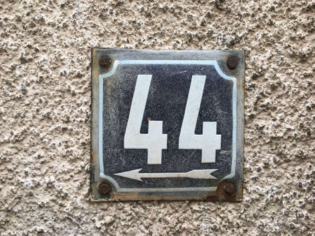 Vintage grunge square metal rusty plate of number of street address with number closeupの素材