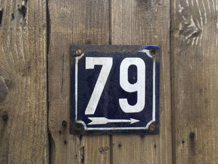 Vintage grunge square metal rusty plate of number of street address with number closeupの素材