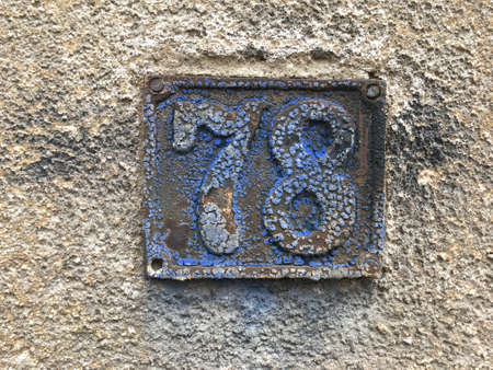 Vintage grunge square metal rusty plate of number of street address with number closeupの素材