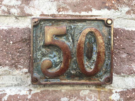 Vintage grunge square metal rusty plate of number of street address with number closeupの素材