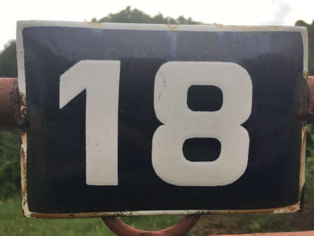 Vintage grunge square metal rusty plate of number of street address with number closeupの素材