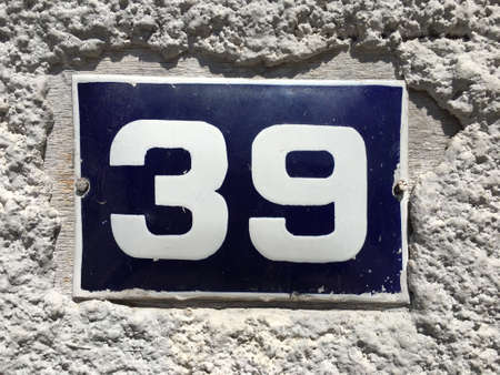 Vintage grunge square metal rusty plate of number of street address with number closeupの素材