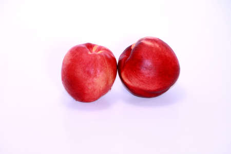 Two sweet and juicy nectarines isolated on white.の写真素材