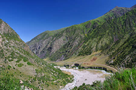 Mountain gorge and river with green trees and blue skyの写真素材