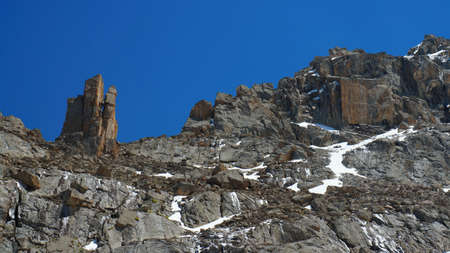 Freakish rocks in Kyrgyz mountains similar to a tower and a square against the background of dark blue skyの写真素材
