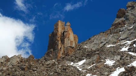 Intricate rocks in Kyrgyz mountains similar to a tower against the background of dark blue skyの写真素材