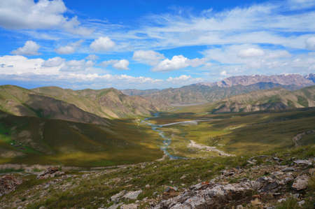 Small mountains, the river and amazing  blue sky with white clouds in Kyrgyzstanの写真素材
