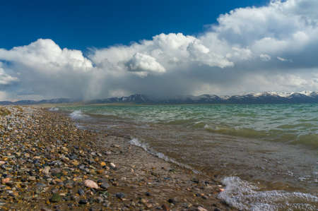A beautiful view of the mountain lake Son-Kul with delightful clouds and blue skyの写真素材