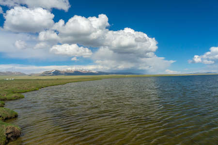 Charming mountain lake Son-Kul, with delightful clouds and blue skyの写真素材