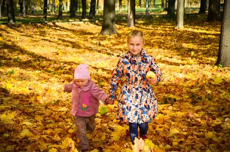 Two little girls running along the park pathの写真素材