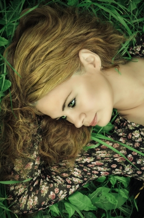 Close-up portrait of a young woman relaxing on grassの写真素材