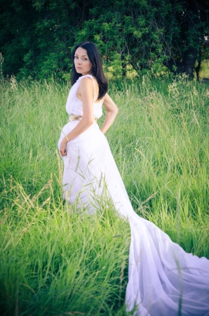 Wedding look of a young woman in the grassの写真素材