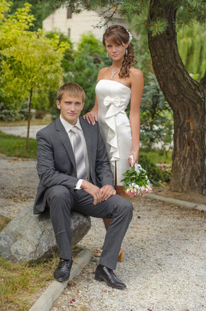 Bride and groom sitting on a stoneの写真素材