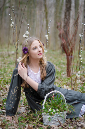 Young pretty girl lying in the grass with a basket of flowersの写真素材