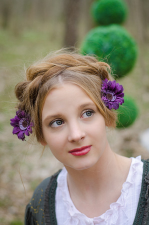 Portrait of a pensive young girl  with decorative flowers in her hairの写真素材