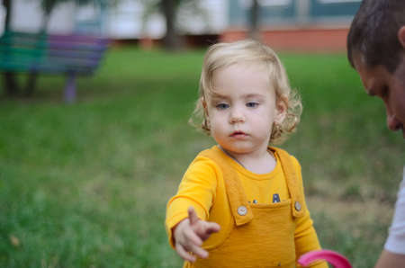 Photo of a blue-eyed toddler girl playing outside on the playgroundの写真素材