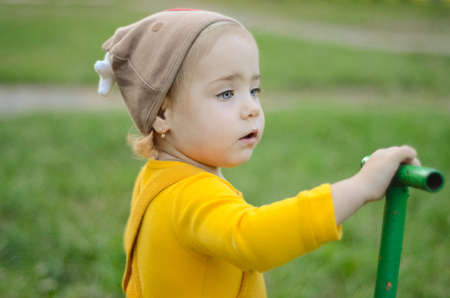 Photo of a blue-eyed toddler girl playing outside on the playgroundの写真素材