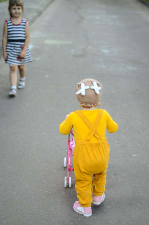 Photo of a blue-eyed toddler girl playing outside on the playgroundの写真素材